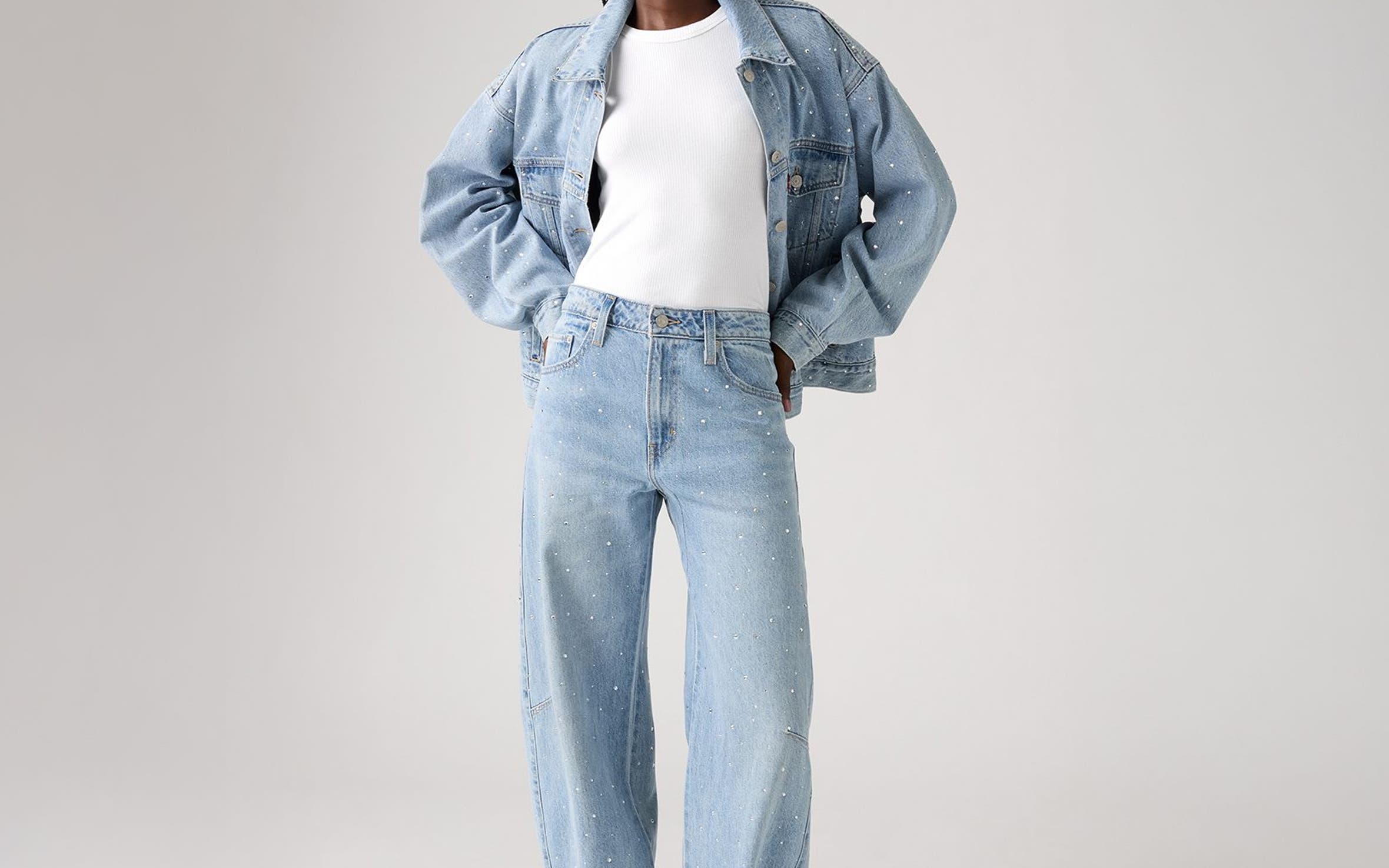 Alt text: A woman wearing an embellished denim jacket and matching jeans.