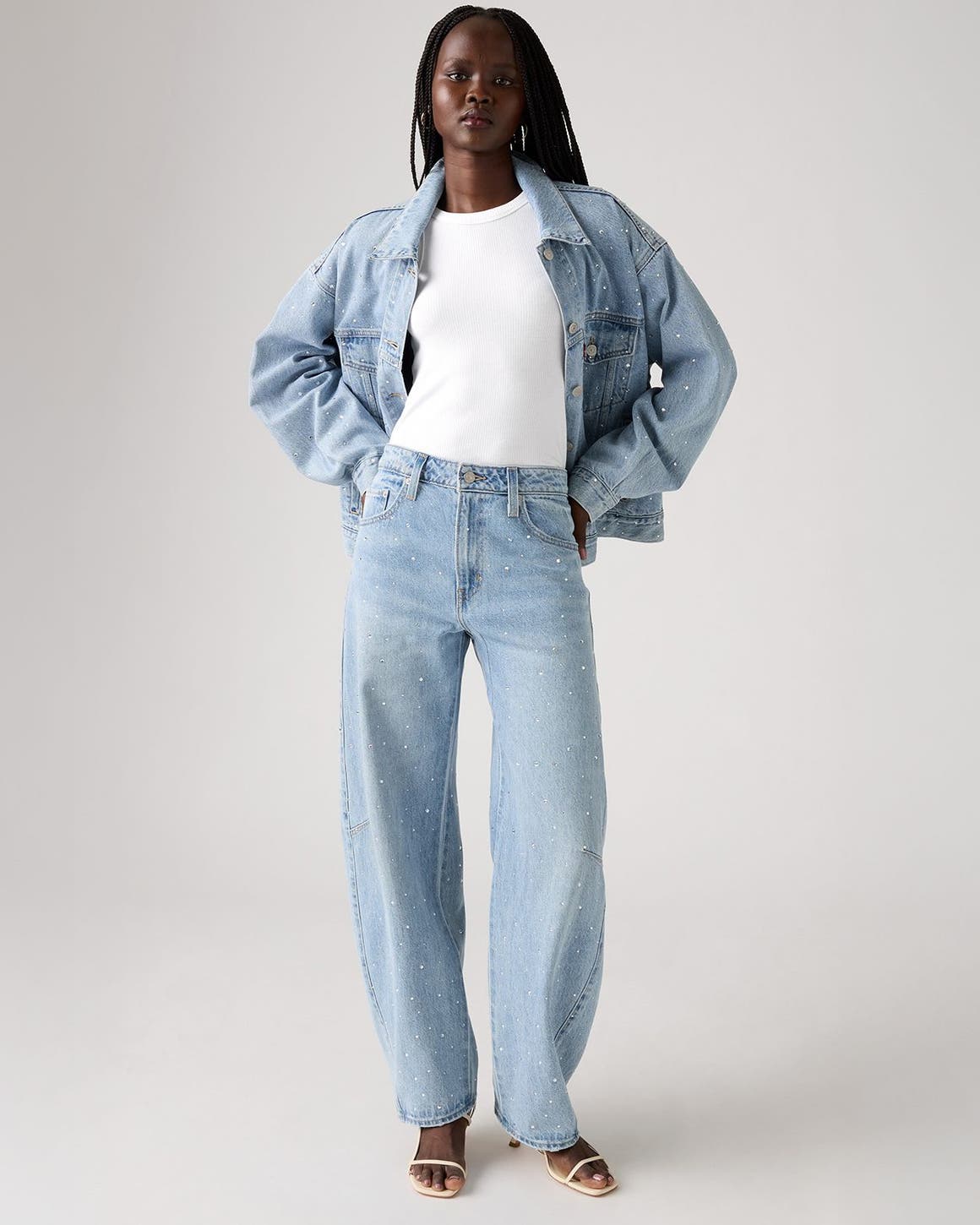 Alt text: A woman wearing an embellished denim jacket and matching jeans.