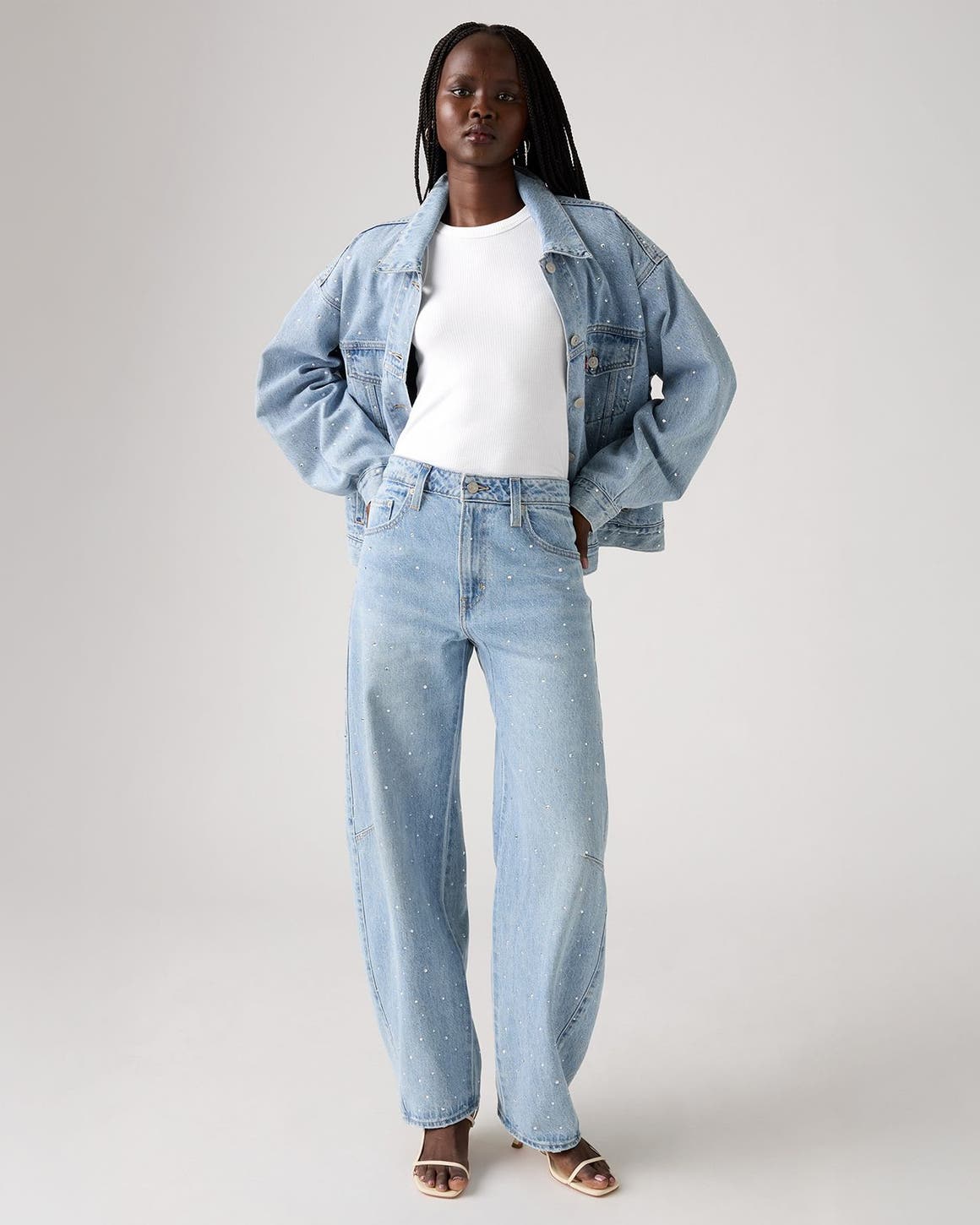 Alt text: A woman wearing an embellished denim jacket and matching jeans.