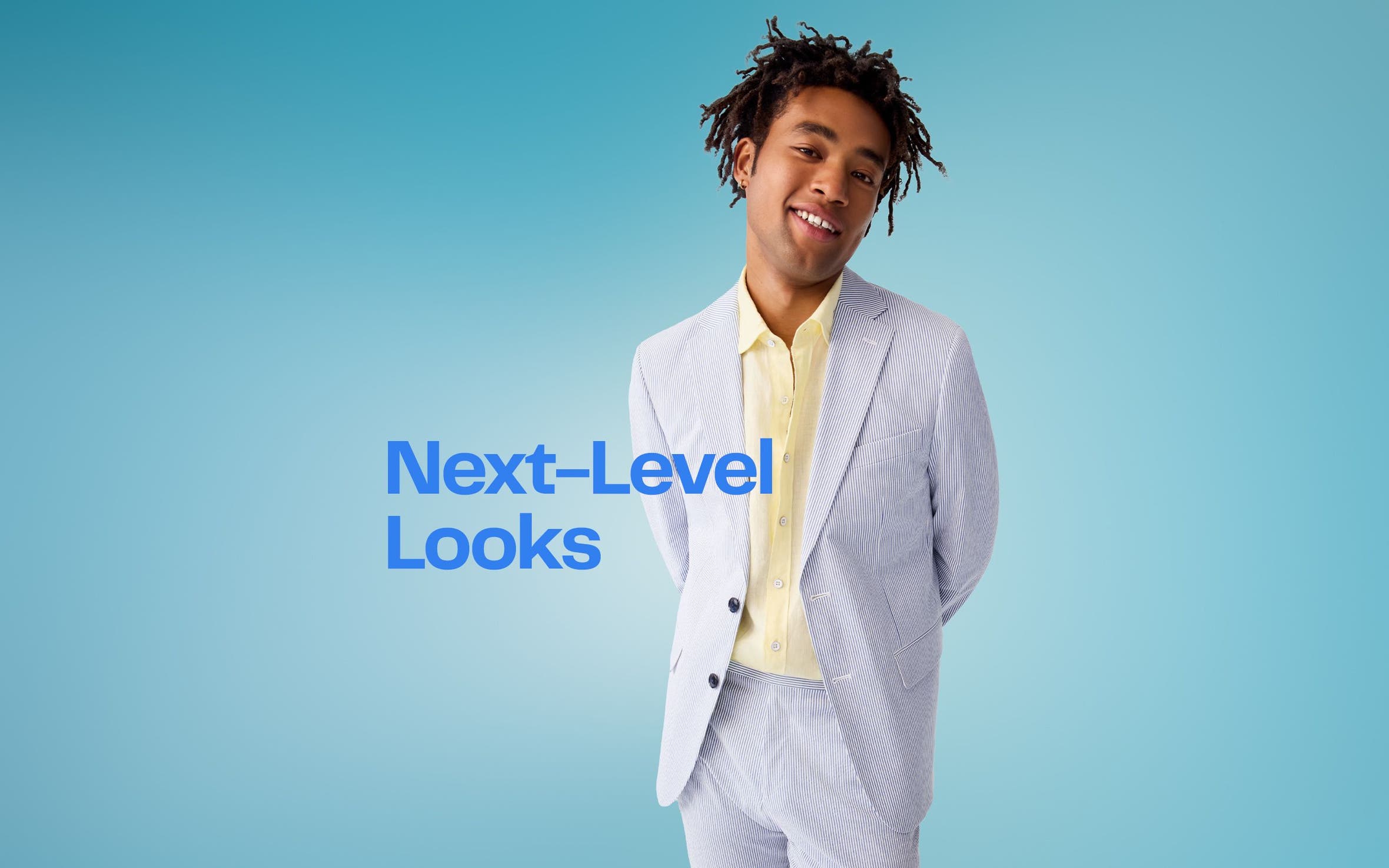 A man wearing a light-blue suit and yellow button-up shirt.