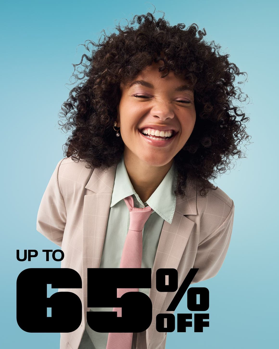 A woman wearing a tan checked suit with a green shirt and pink necktie.
