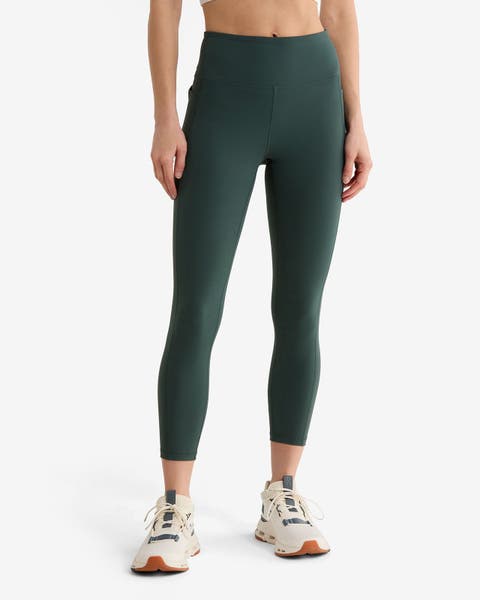 A woman wearing green leggings from Z by Zella and sneakers.