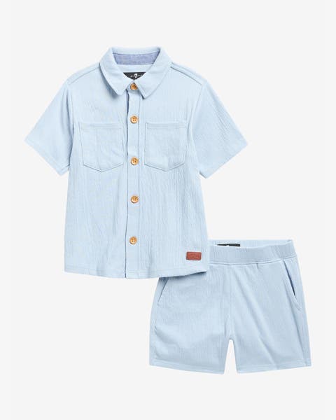 A boys' light blue short‑sleeve button‑up shirt with chest pockets and matching elastic‑waist shorts.