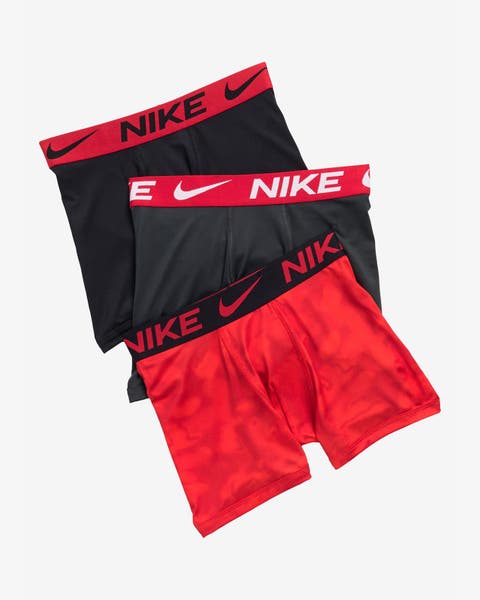 3-pack boys’ Nike boxer briefs, two black, one red camo, with red logo waistbands.