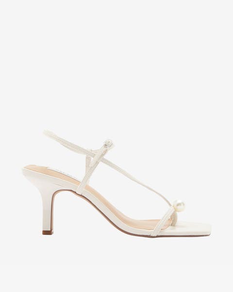 White strappy mid‑heel sandal with pearls.