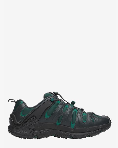 A men's black and green trail running shoe.