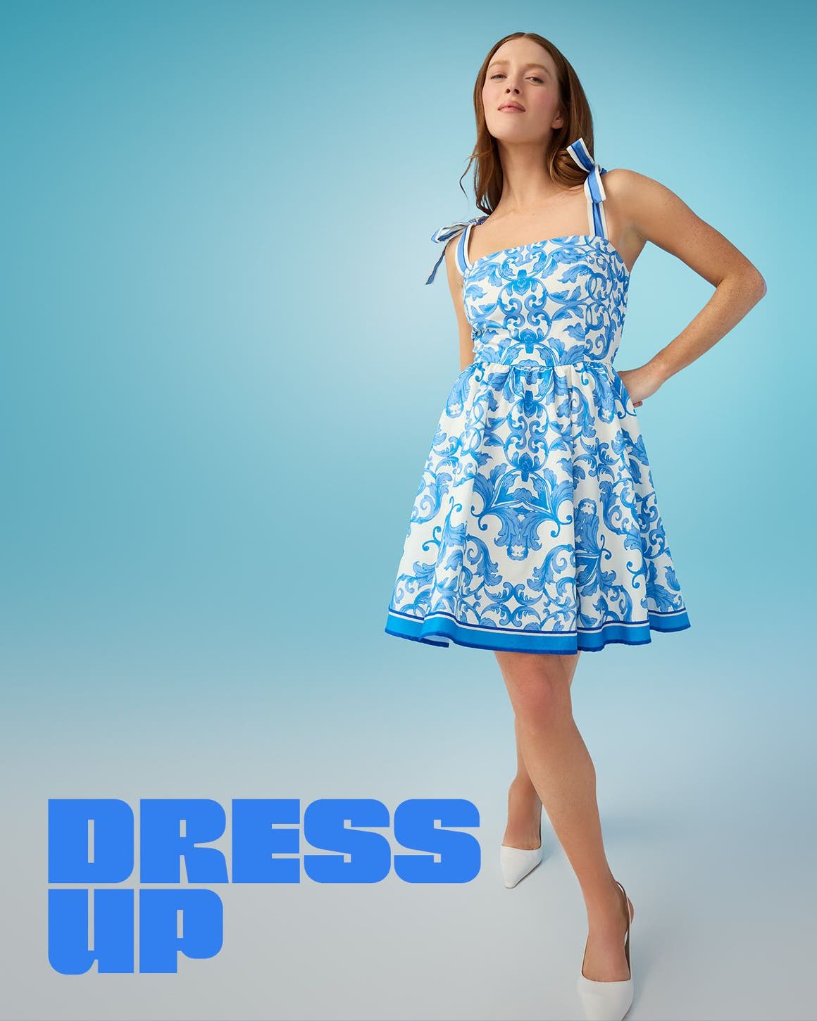 Model wearing a blue and white floral print fit-and-flare sundress with tie shoulders.