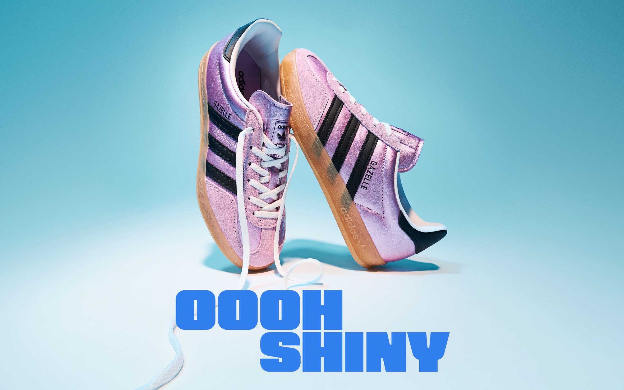 A pair of shiny pink adidas sneakers.