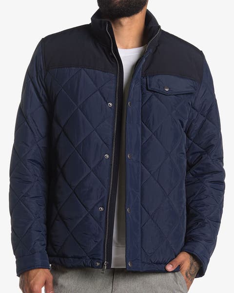 Men's navy blue quilted jacket with contrast yoke and chest pocket.