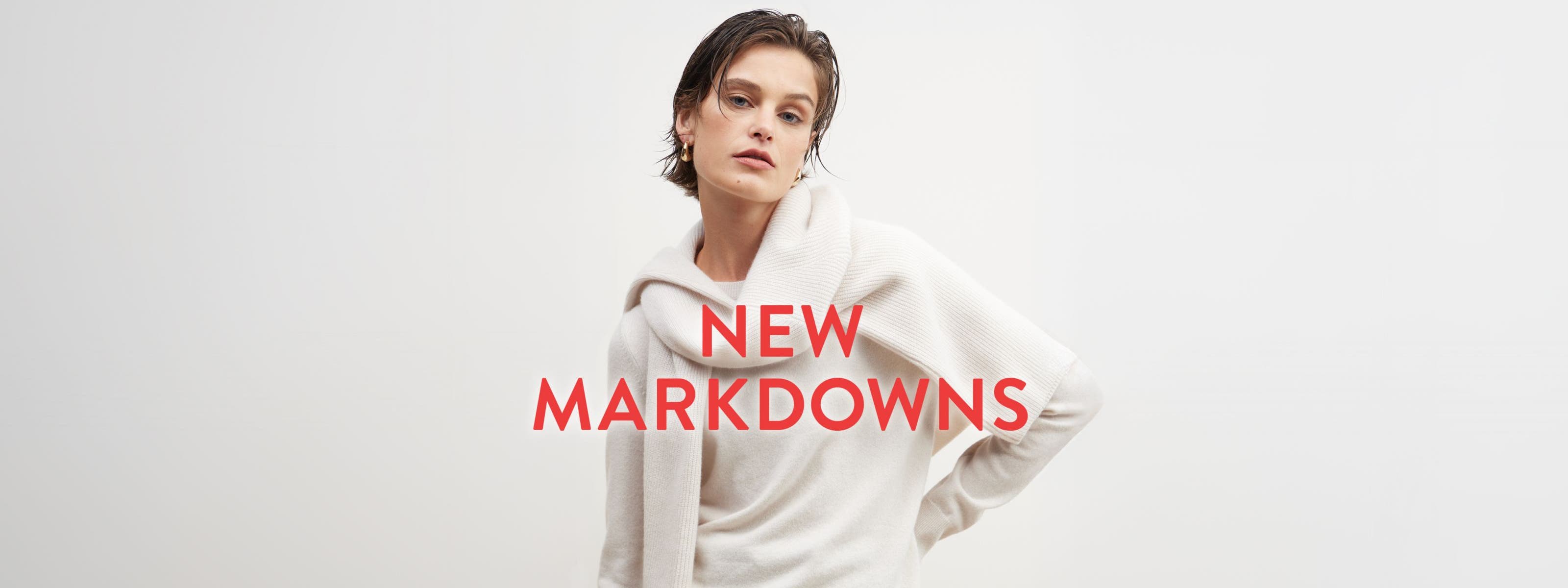 New markdowns: a woman in a beige sweater with another sweater tied around her shoulders.