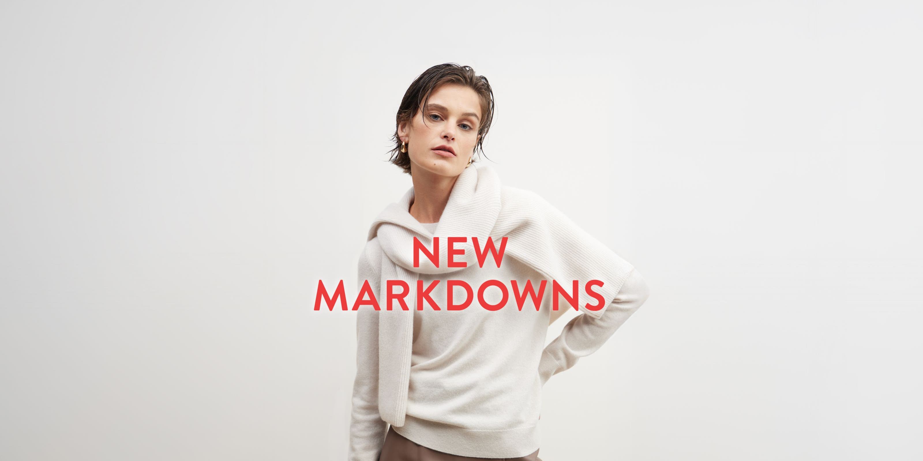 New markdowns: a woman in a beige sweater with another sweater tied around her shoulders.