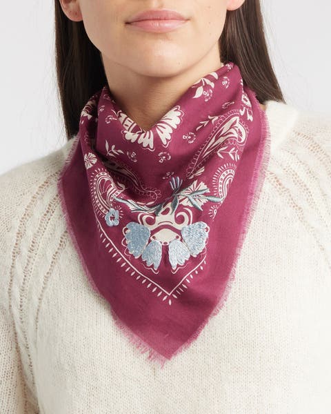 A woman wearing a red, blue and white floral bandana around her neck.