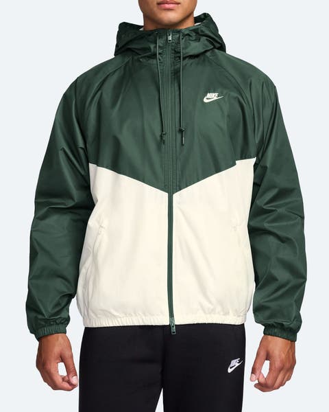 A man wearing a green and whote Nike jacket.