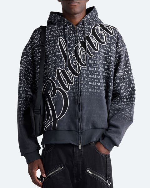 A man wearing a logo hoodie from Balenciaga.