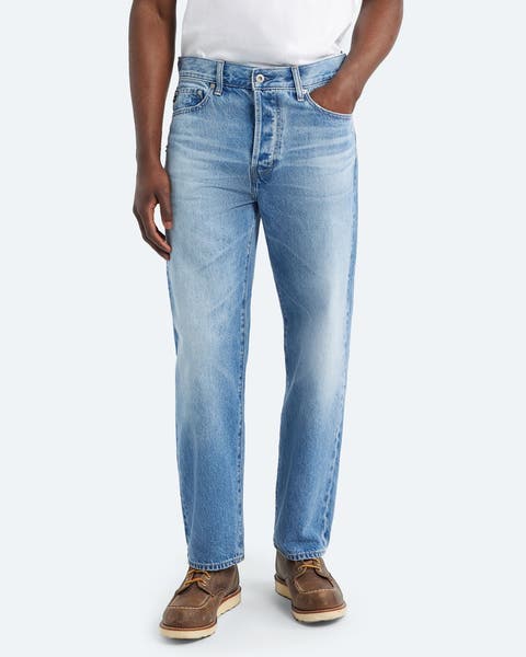 A man wearing faded jeans.