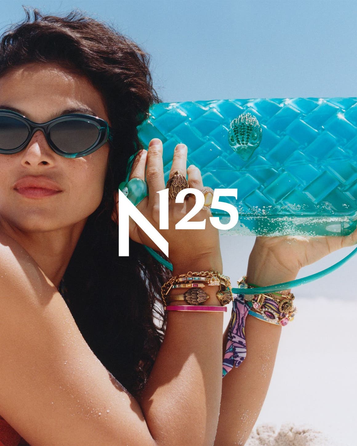 A woman on the beach holding a blue jelly bag.