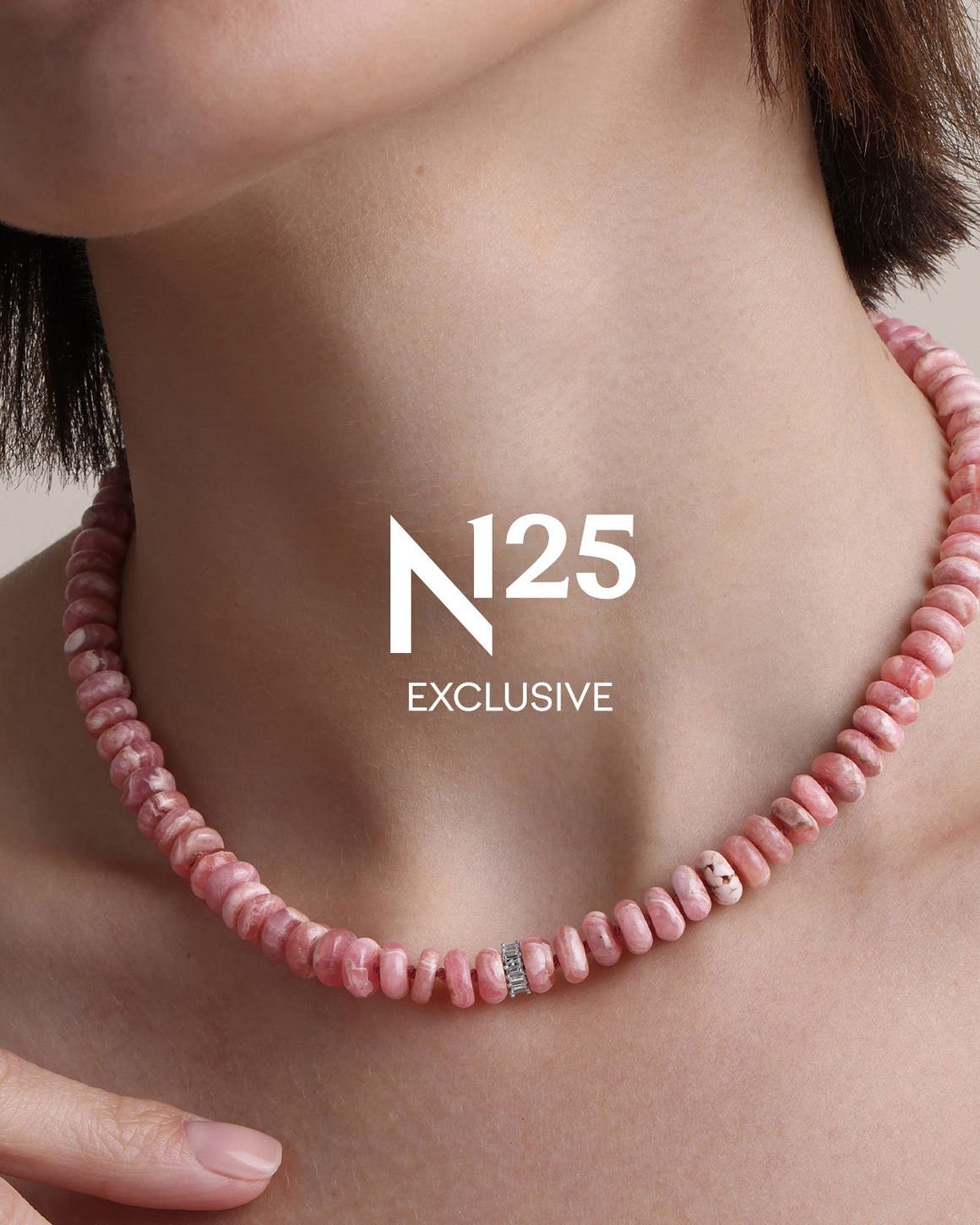 A woman wearing a necklace made of pink beads. 