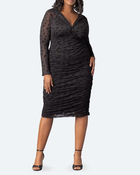 A woman wearing a black ruched body-con dress.