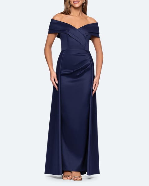 A woman wearing a navy blue off-the-shoulder gown