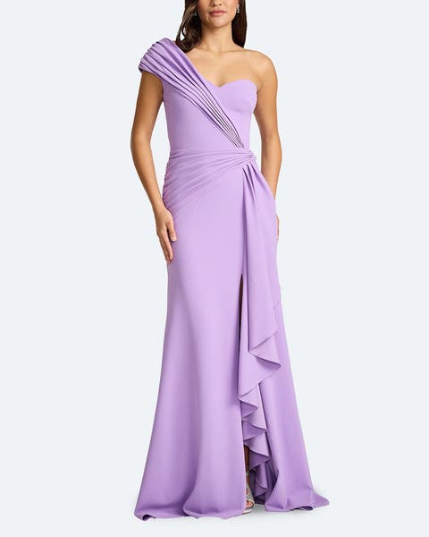 A woman wearing a purple one-shoulder mermaid gown.