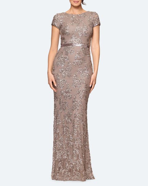 A woman wearing a champagne-colored sequin column dress.