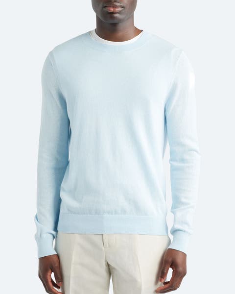 A man wearing a light blue crewneck sweater.