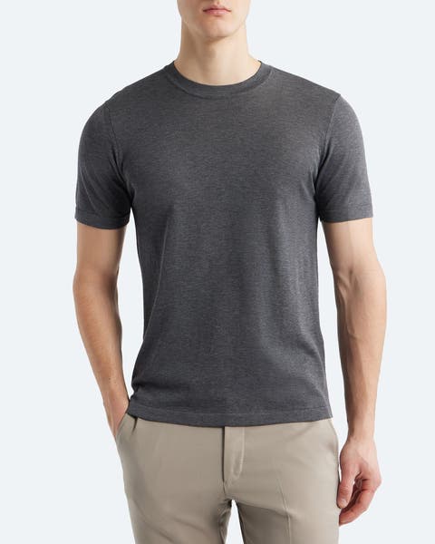 A man wearing a short-sleeve grey sweater.