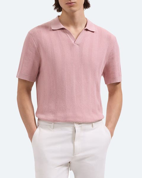 A man wearing a light pink polo-neck sweater.