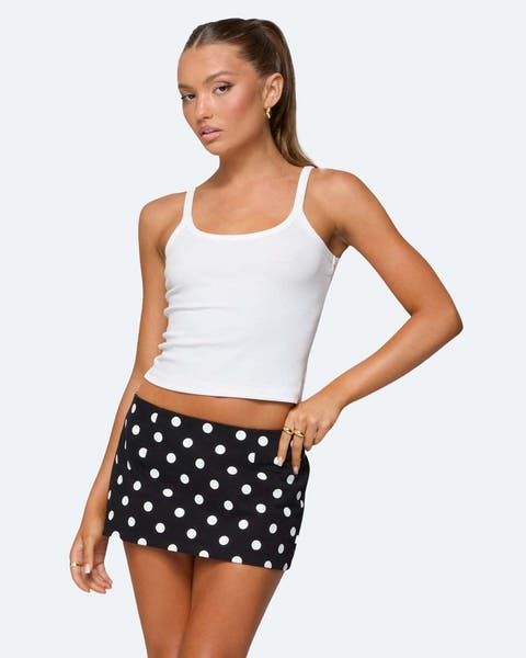 A woman wearing a polka dot mini skort and tank top. 