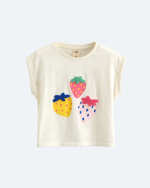 A cream colored t-shirt with applique strawberries.