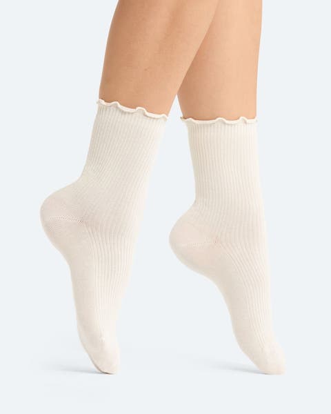 A pair of white socks with lettuce edge trim. 