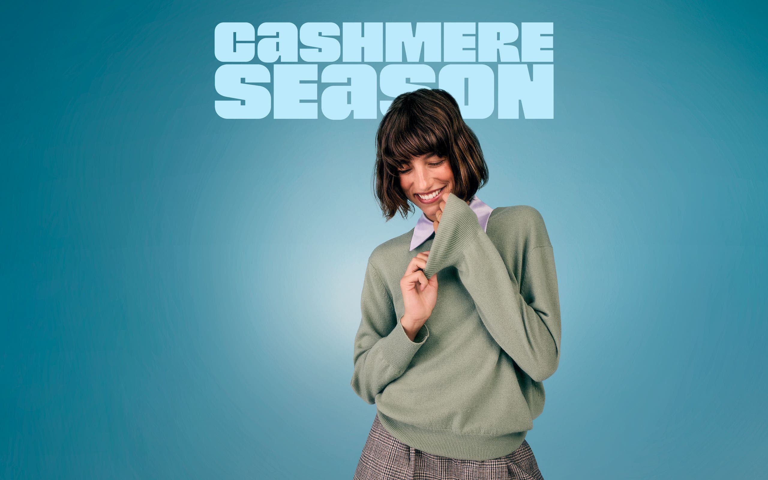 Woman in an oversized sage green cashmere sweater.