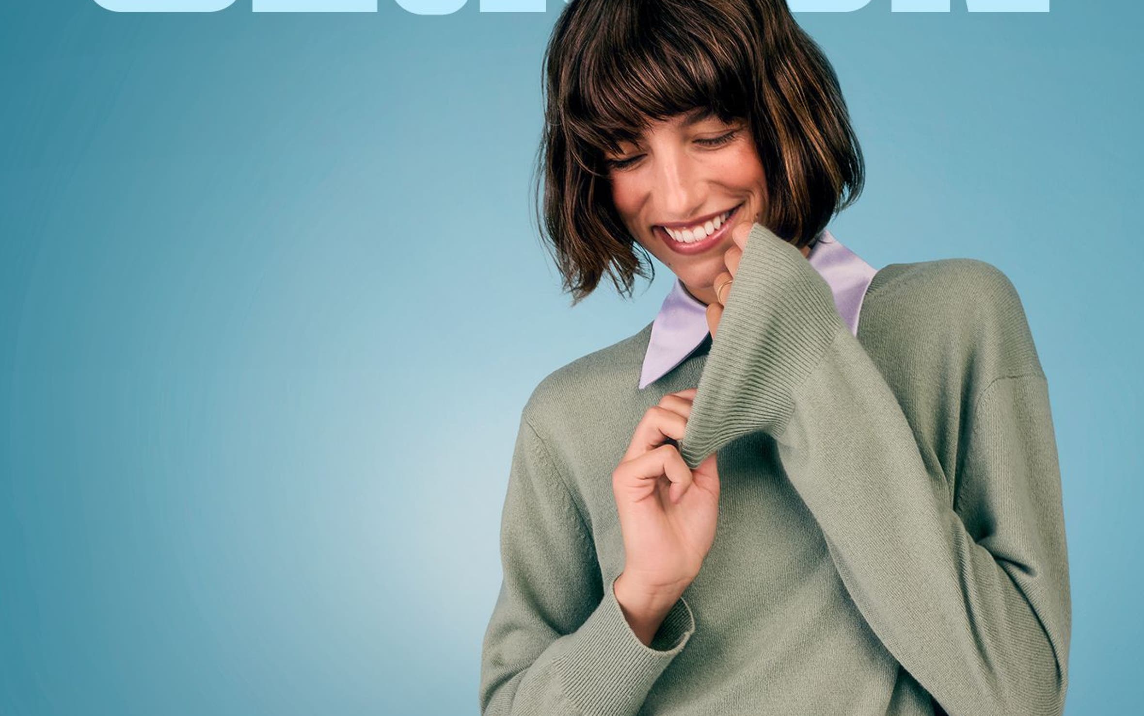 Woman in an oversized sage green cashmere sweater.