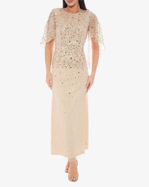 Model wearing a champagne sequin ombré maxi dress with flutter sleeves and nude heels.