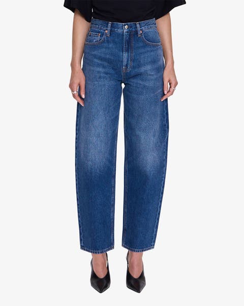 A women in barrel jeans and black shoes.