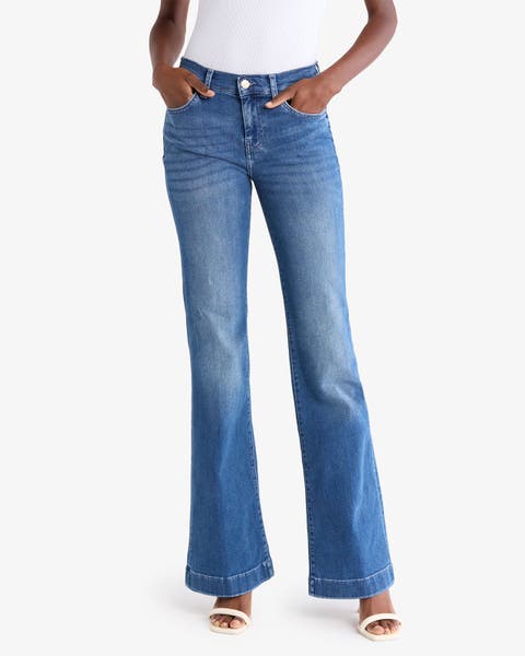 A woman in flare jeans and white sandals.