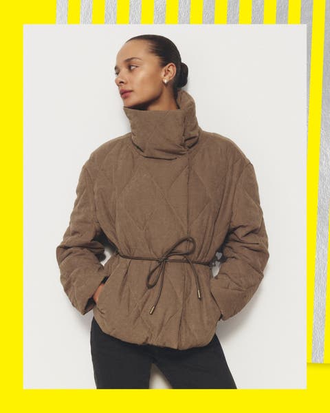 A woman in a brown quilted high-neck cropped jacket.