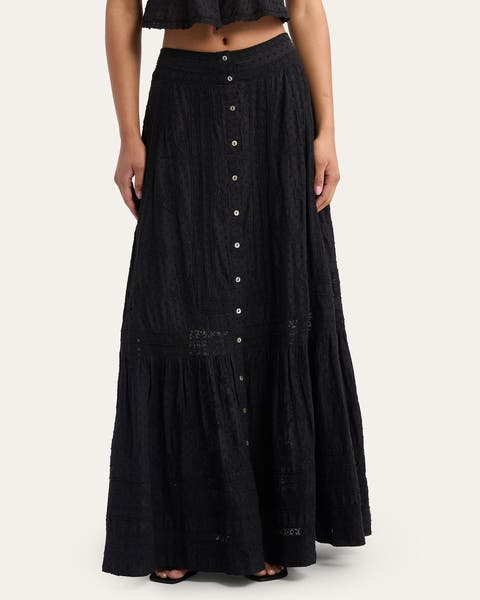 A woman wearing a black cotton maxi skirt.