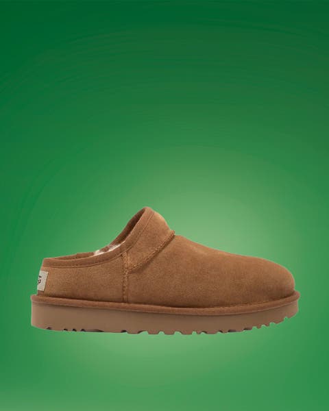 Chestnut suede shearling-lined slipper clog on green.
