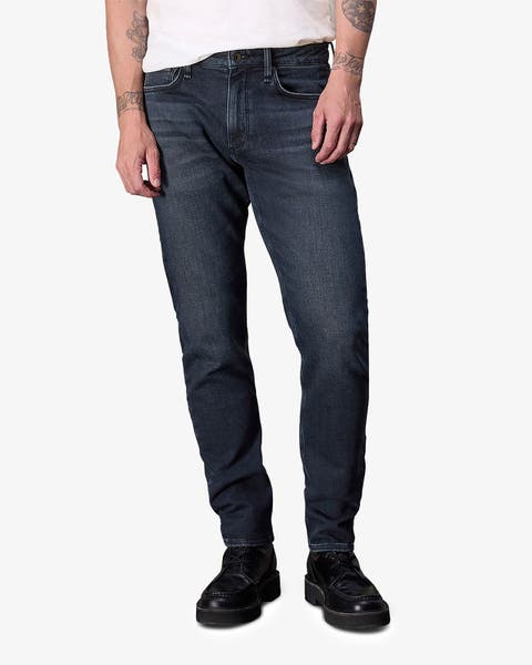 Slim dark-wash jeans styled with a white tee and black lace-ups.