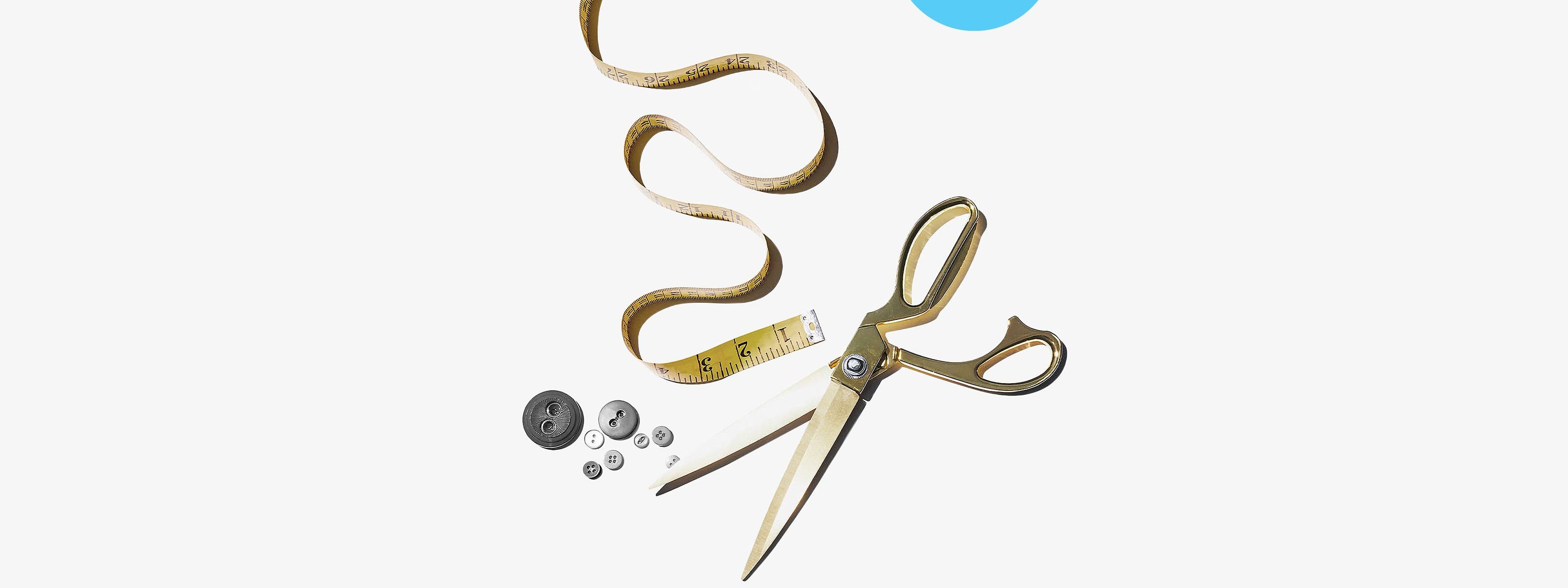 Expert tailoring. A pair of scissors, a measuring tape and buttons.