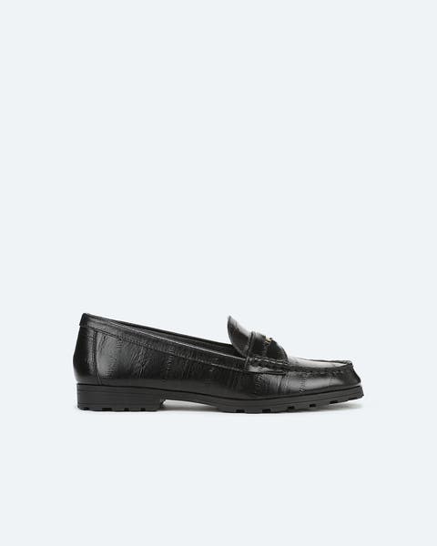 A pair of black croc-emboss loafers.