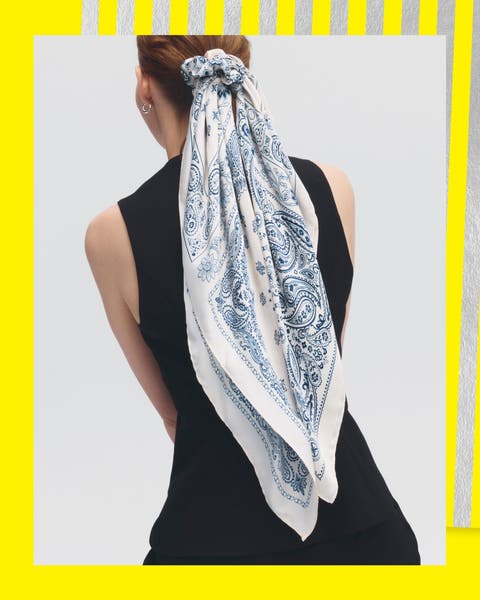 A woman with a blue and white scarf styled in her hair.