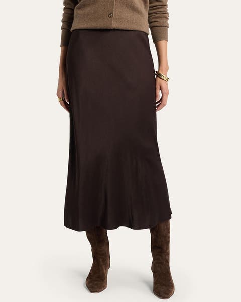 A woman wearing a brown satin midi skirt.