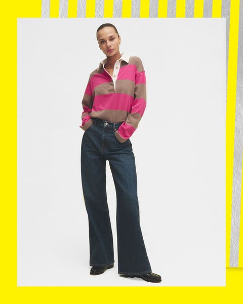 A woman wearing wide leg jeans and a long sleeve polo shirt.