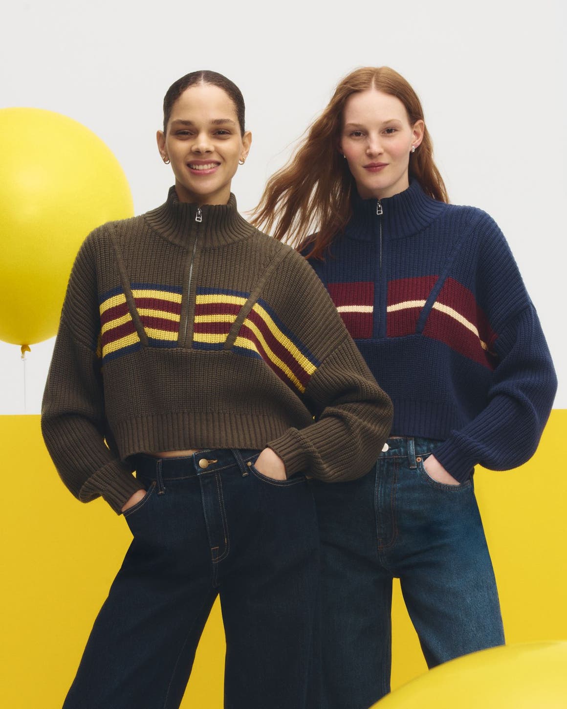 Two women wearing sweaters & jeans.