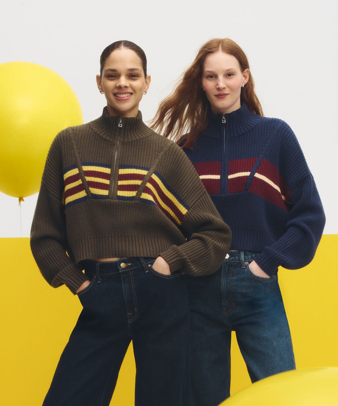 Two women wearing sweaters & jeans.
