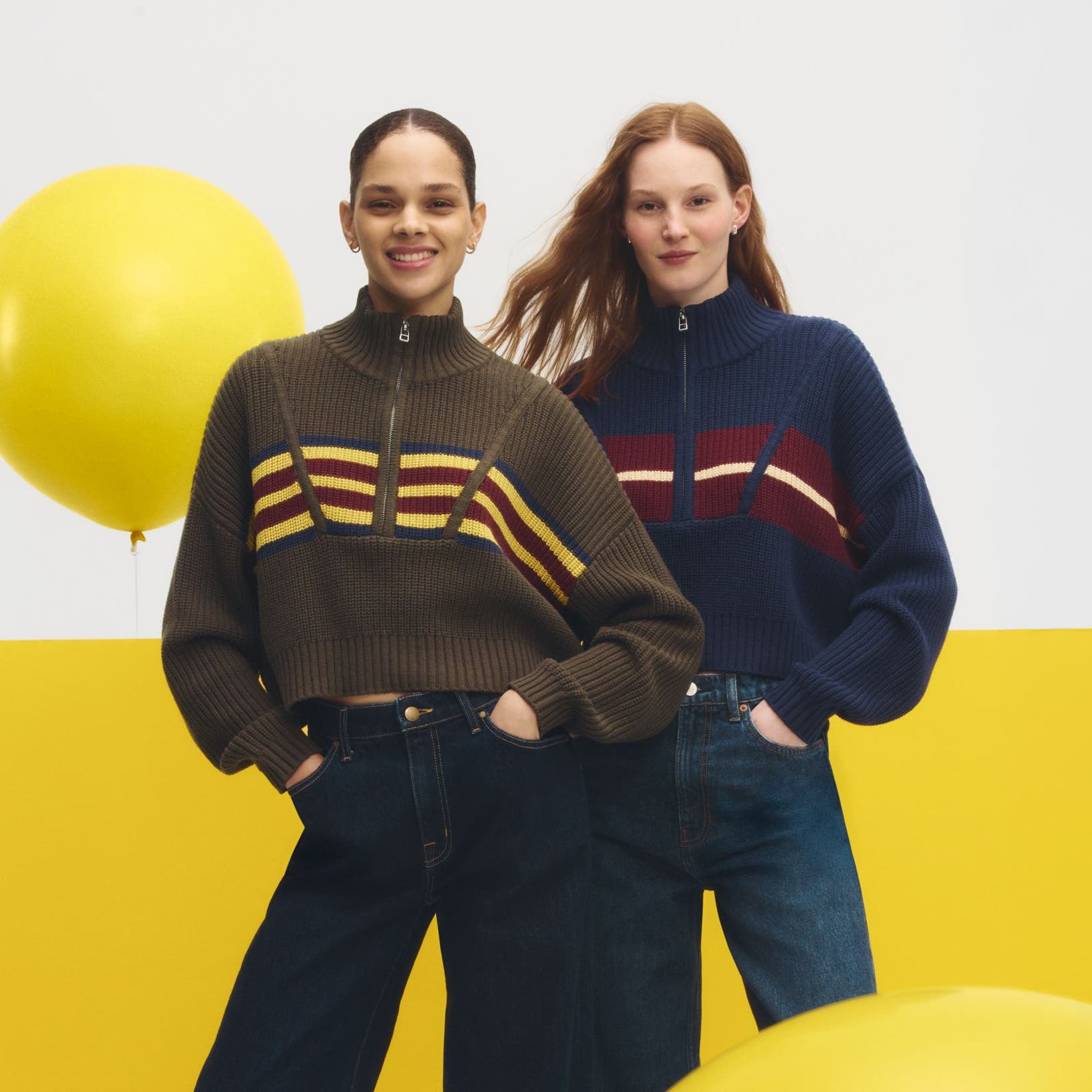 Two women wearing sweaters & jeans.