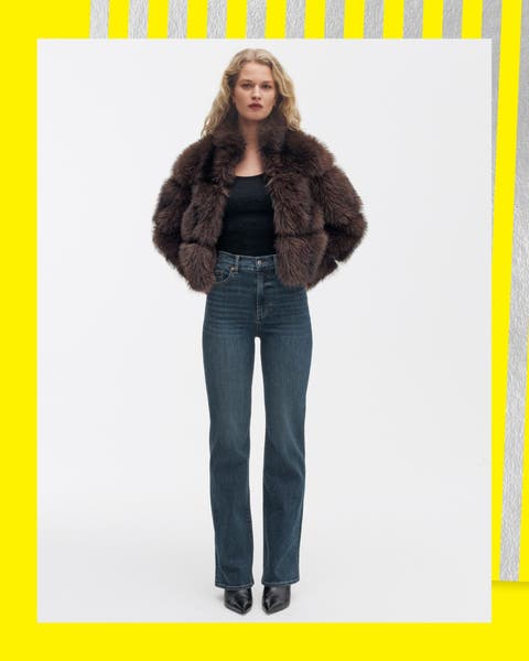 A woman wearing a faux fur jacket and straight leg jeans.