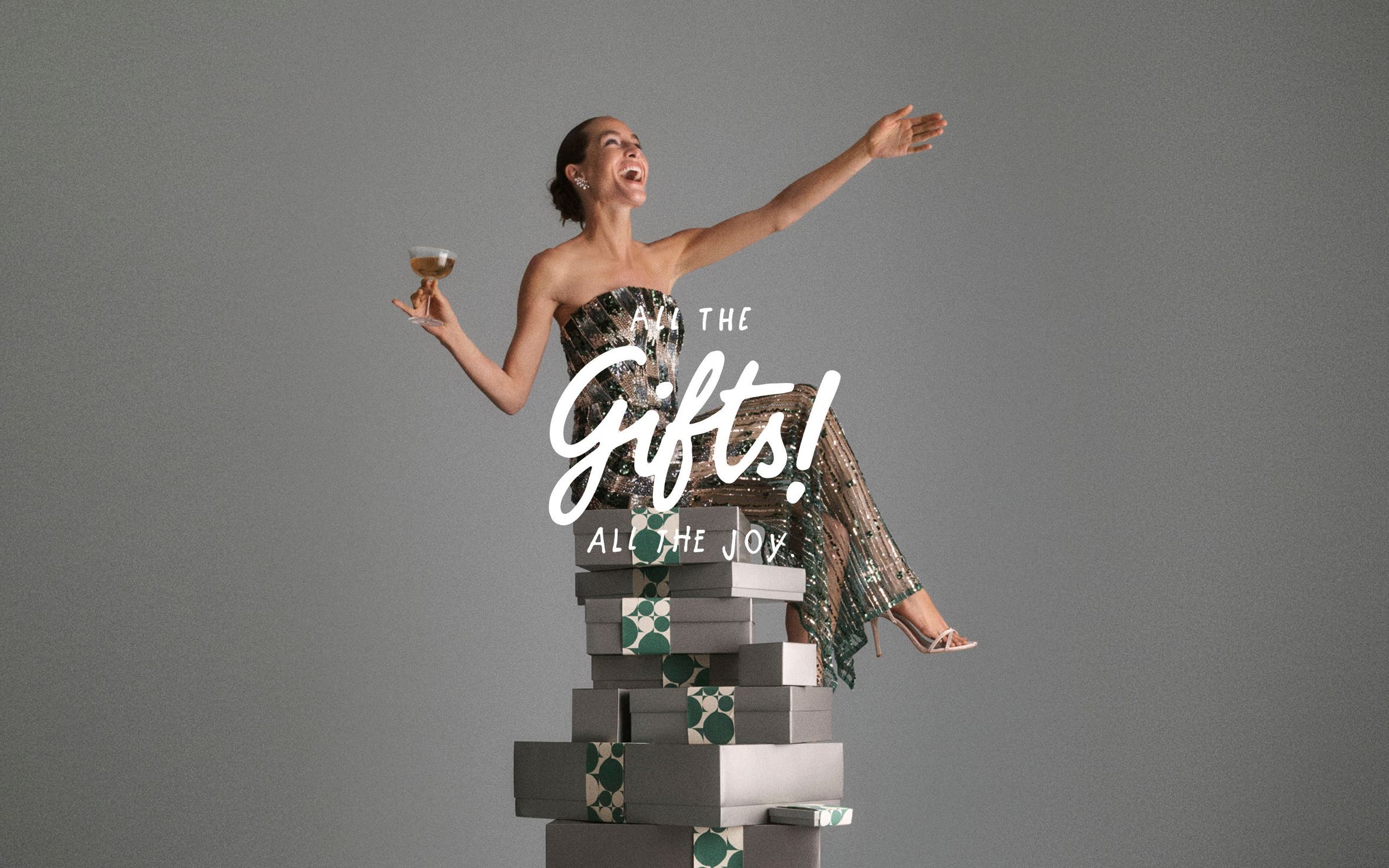 All the gifts, all the joy. A woman sitting on a tower of gift boxes.